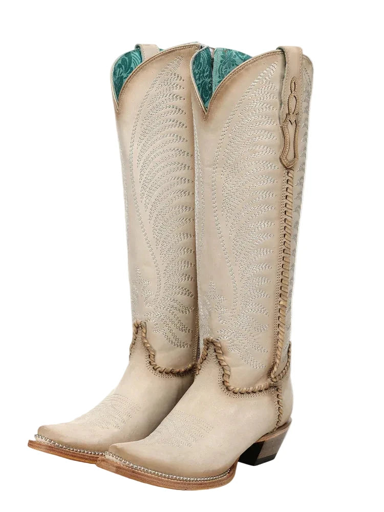 Pair of beige cowboy boots with intricate designs on a white background