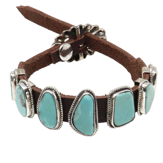 Bracelet with turquoise stones and brown leather strap on a white background