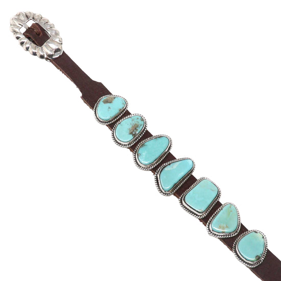 Turquoise stone and brown leather belt with silver conchos on a white background