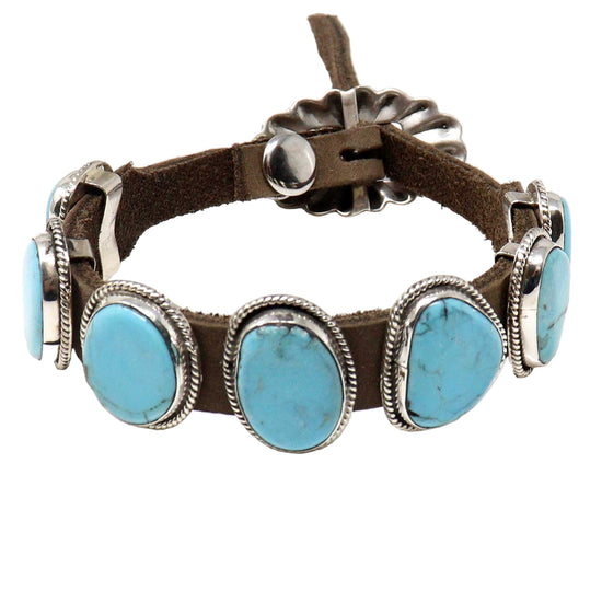 Bracelet with turquoise stones and brown leather strap on a white background