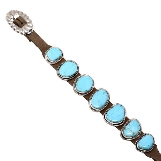 Bracelet with turquoise stones and brown leather strap on a white background