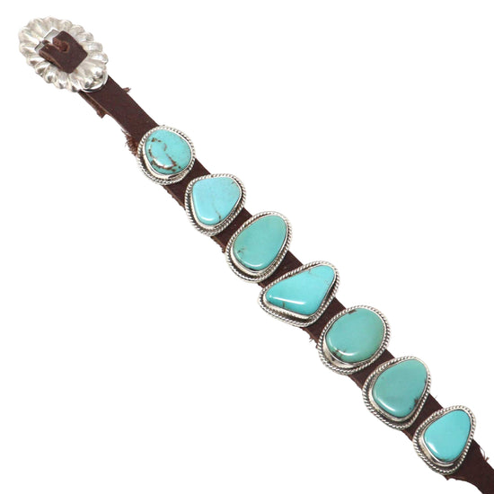 Turquoise stone and brown leather belt with silver buckle on a white background