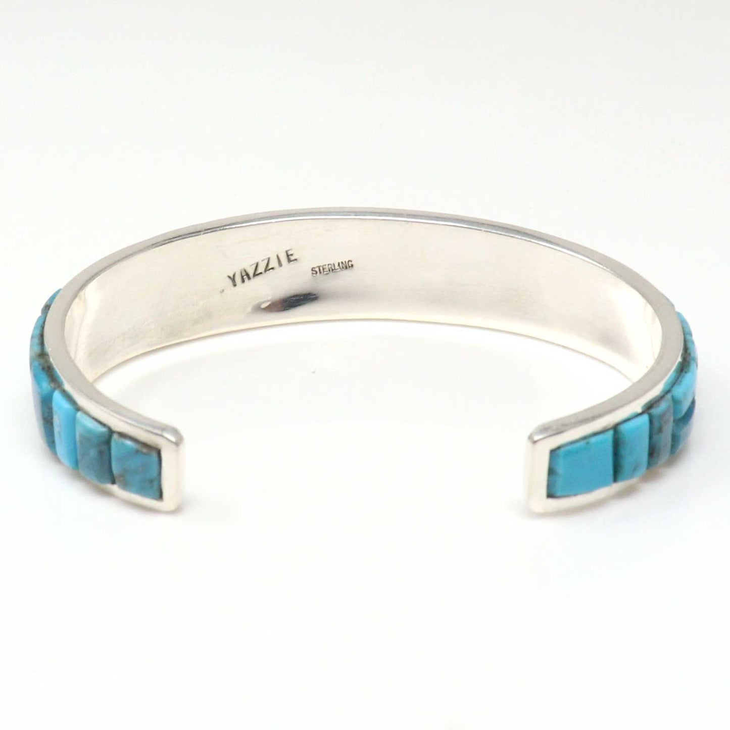 Silver bracelet with turquoise inlay on a white background