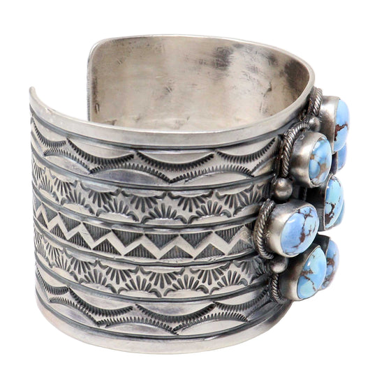 Silver cuff bracelet with turquoise stones on a white background