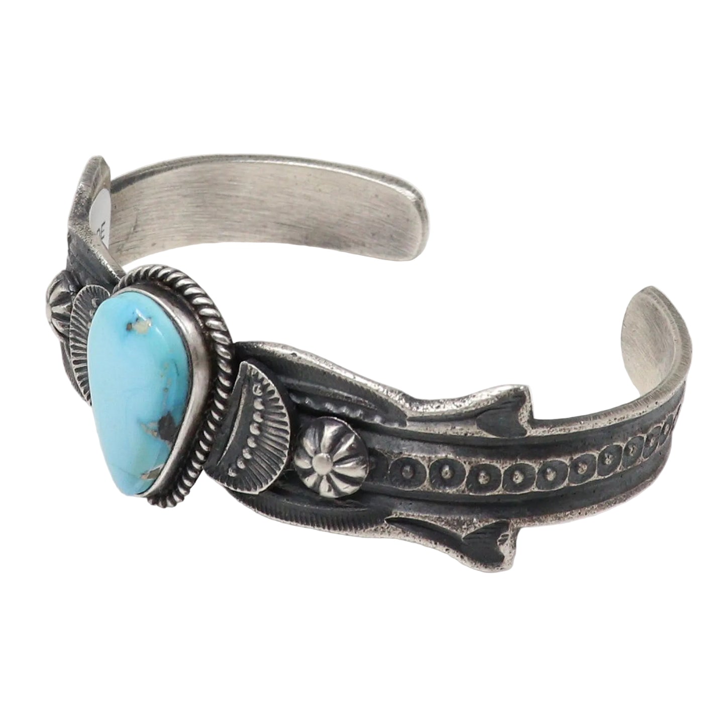 A sterling silver cuff bracelet featuring a large oval turquoise stone and detailed hand-stamped Native American style motifs, shown on a plain white background.