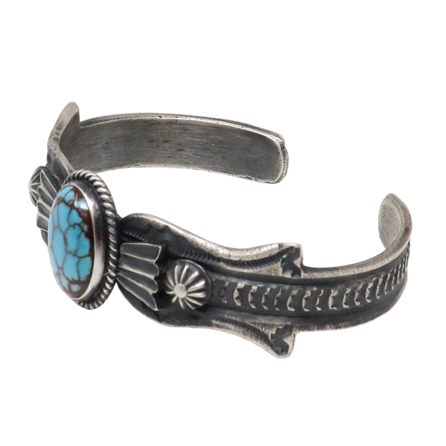 A sterling silver cuff bracelet featuring a turquoise stone in a bezel setting, with detailed hand-hammered and engraved patterns on the band, shown against a plain white background.