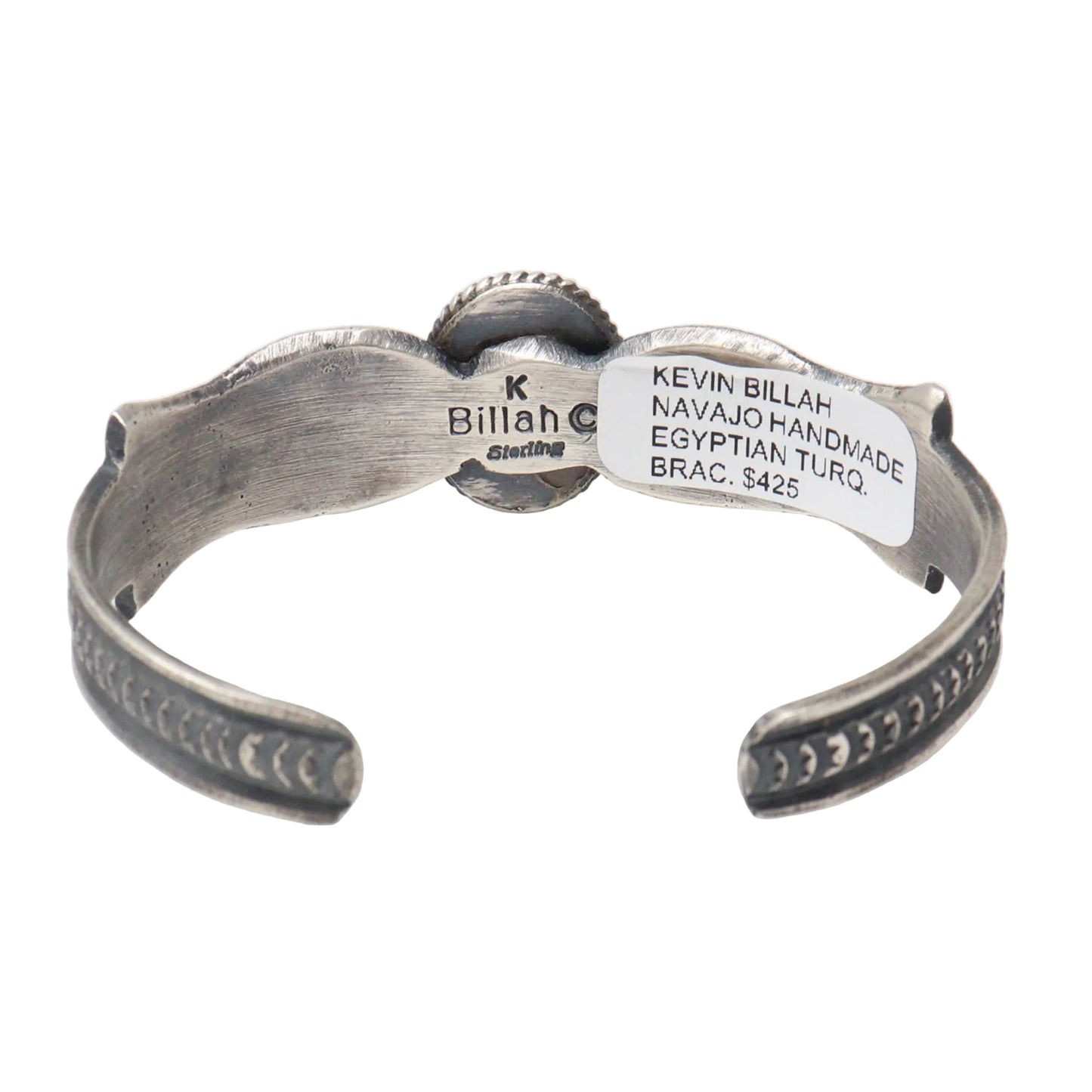 A sterling silver open cuff bracelet with hand-stamped details and a white paper label showing the brand 'Kevin Billah' and 'Navajo Handmade'.