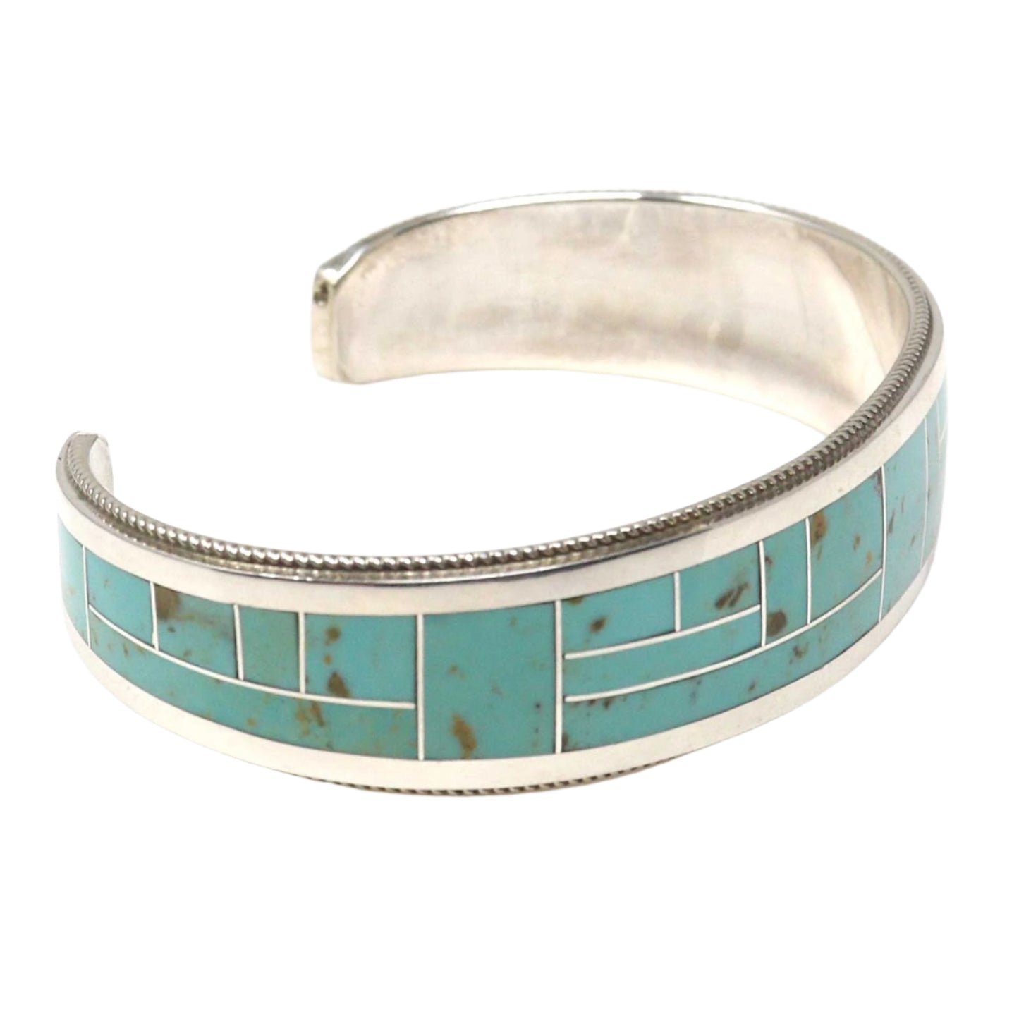 Silver bracelet with turquoise inlay on a white background