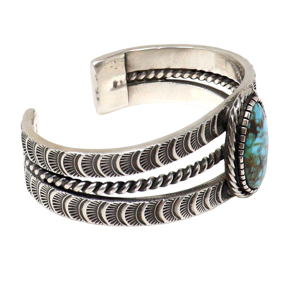 Silver bracelet with turquoise stone on a white background