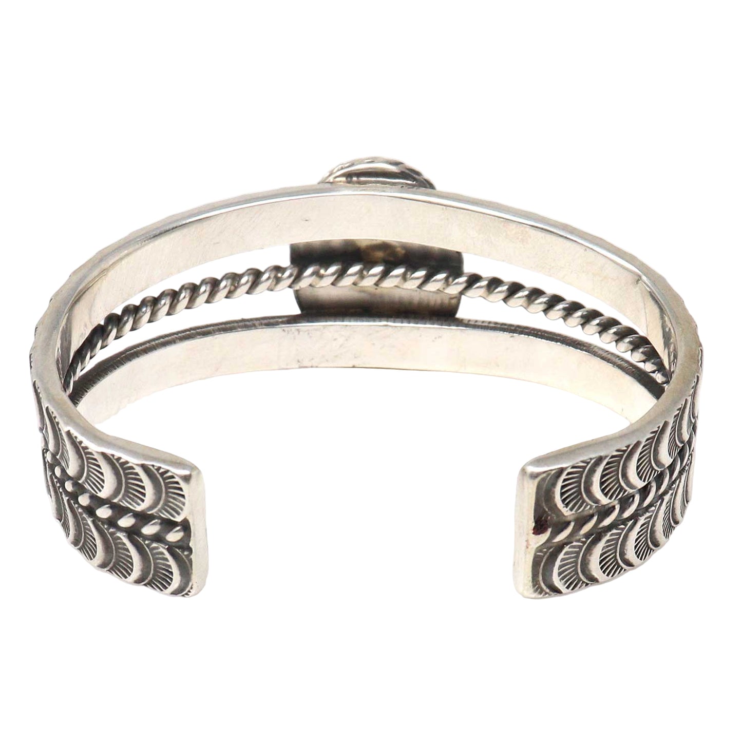 Silver bracelet with intricate designs on a white background