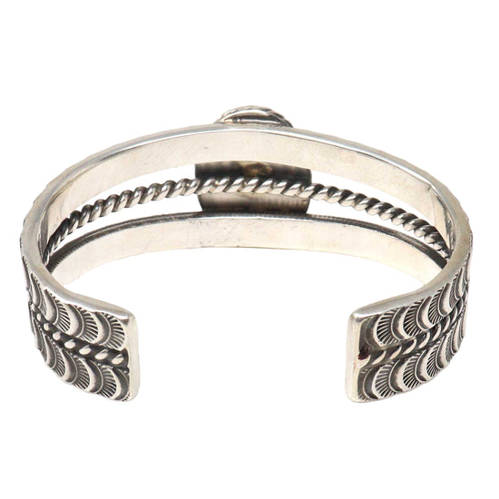 Silver bracelet with intricate designs on a white background