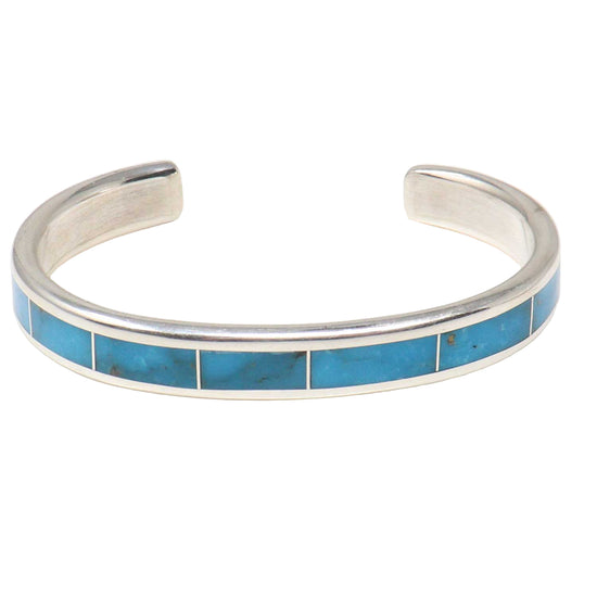 Silver bracelet with turquoise inlay on a white background