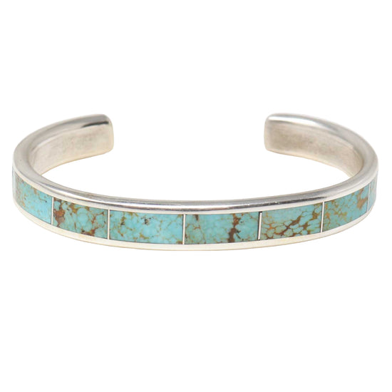Silver bracelet with turquoise inlay on a white background