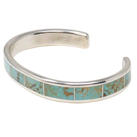 Silver bracelet with turquoise inlay on a white background