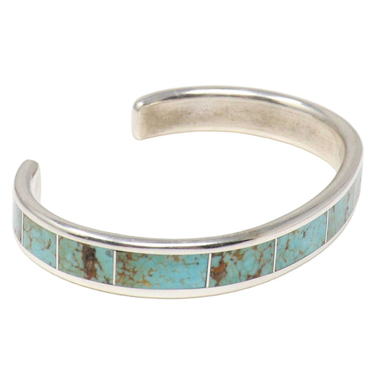 Silver bracelet with turquoise inlay on a white background