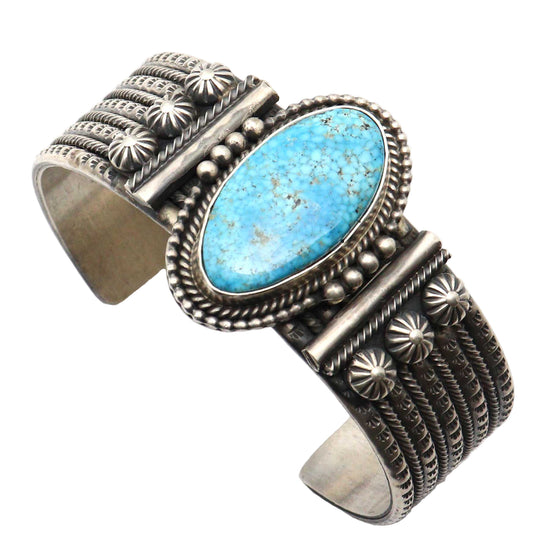 Silver cuff bracelet with a large turquoise stone on a white background