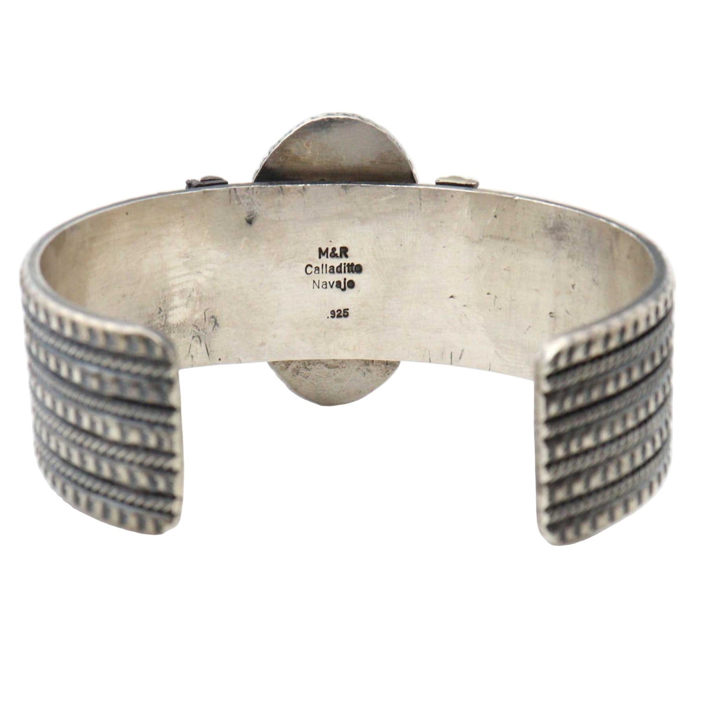 Silver bracelet with intricate designs on a white background