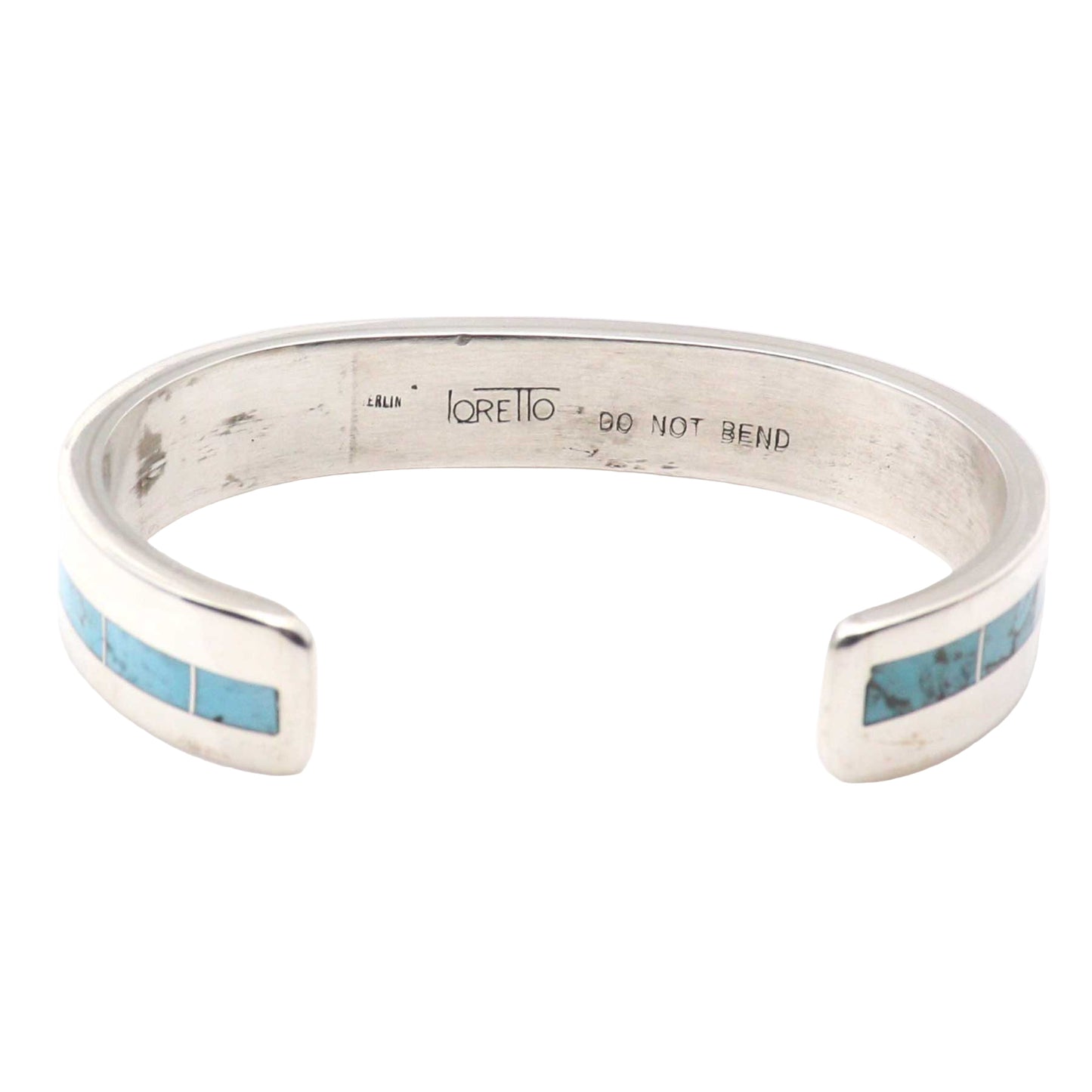 Silver bracelet with turquoise inlay on a white background