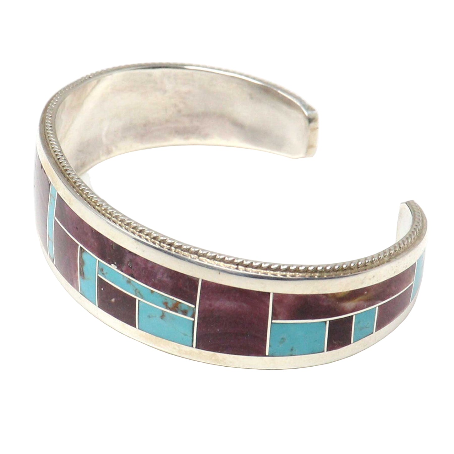 Silver bracelet with turquoise and purple inlay on a white background
