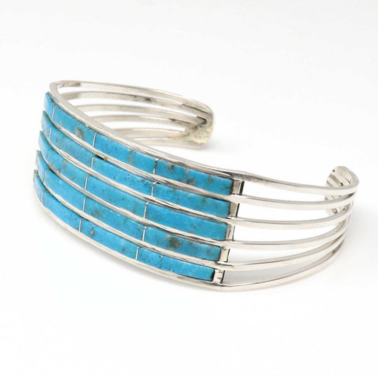 Silver bracelet with turquoise inlay on a white background