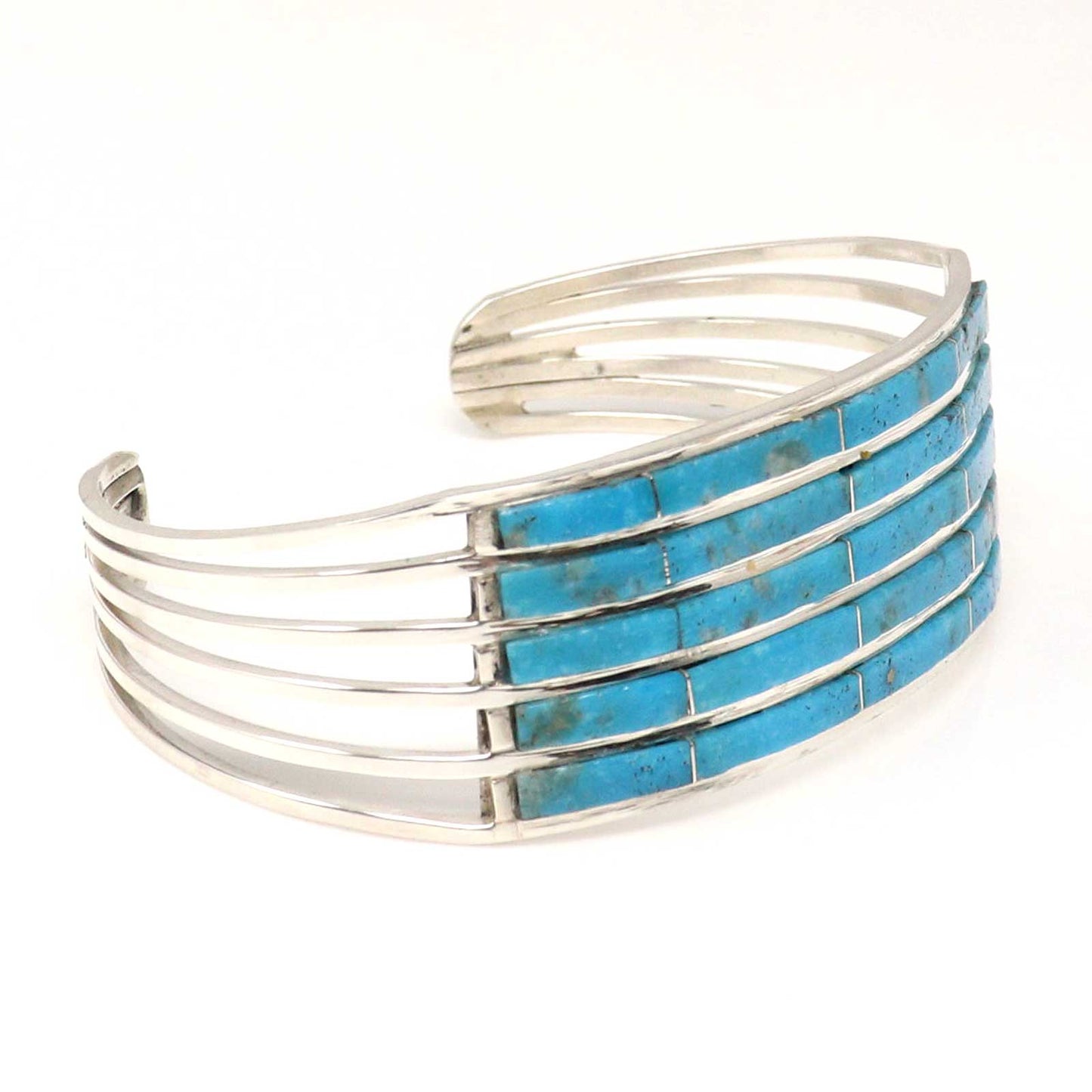 Silver cuff bracelet with turquoise inlay on a white background