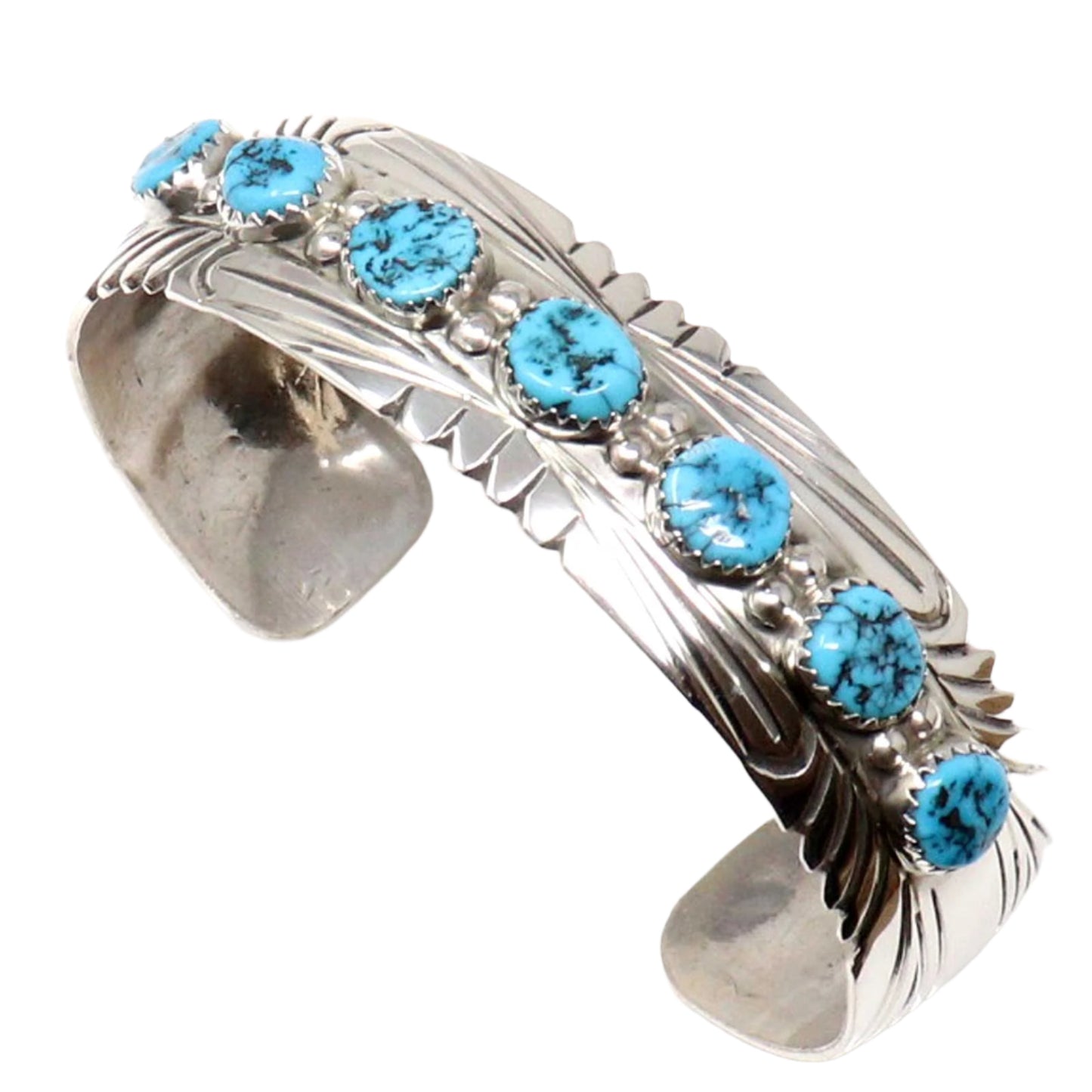 Silver cuff bracelet with turquoise stones on a white background