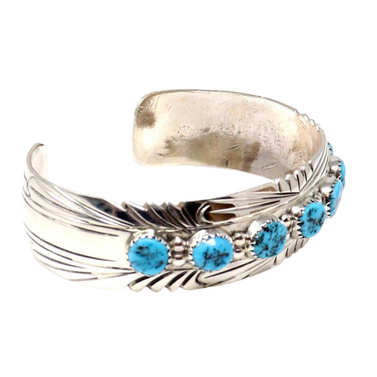 Silver bracelet with turquoise stones on a white background