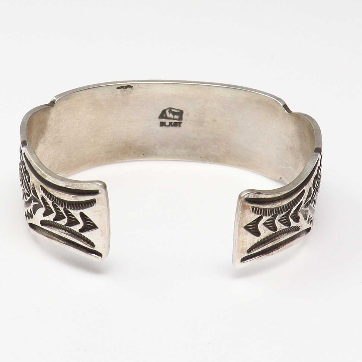 Silver bracelet with tribal designs on a white background