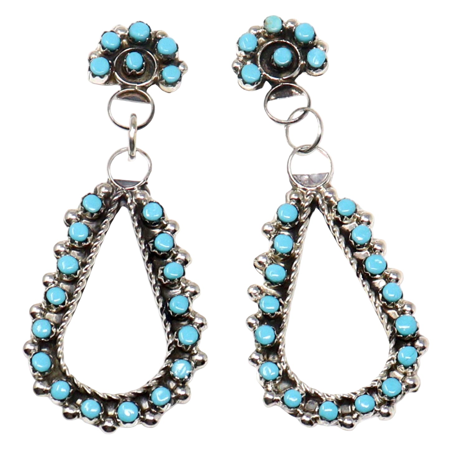 Pair of silver earrings with turquoise stones on a white background