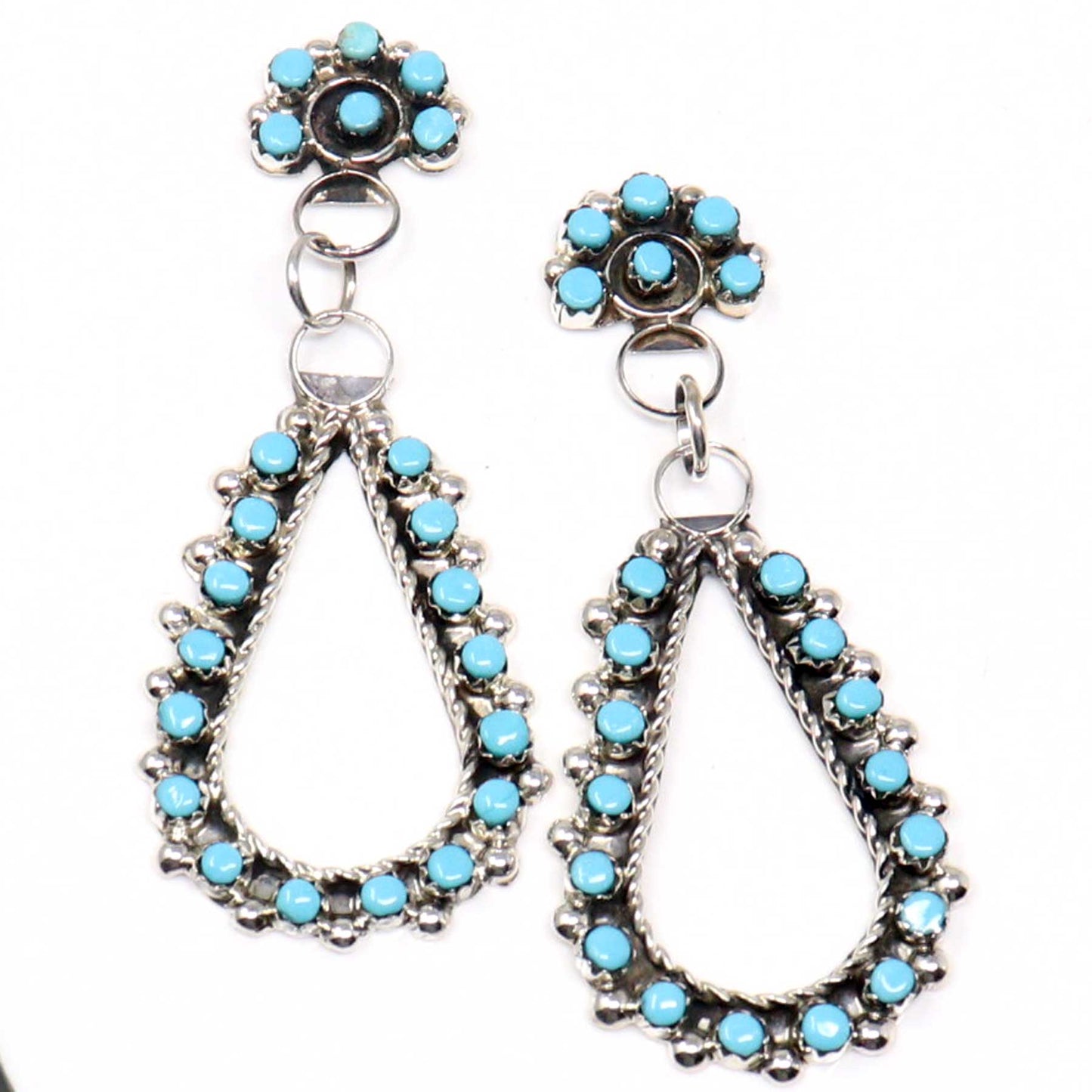 Pair of silver earrings with turquoise stones on a white background