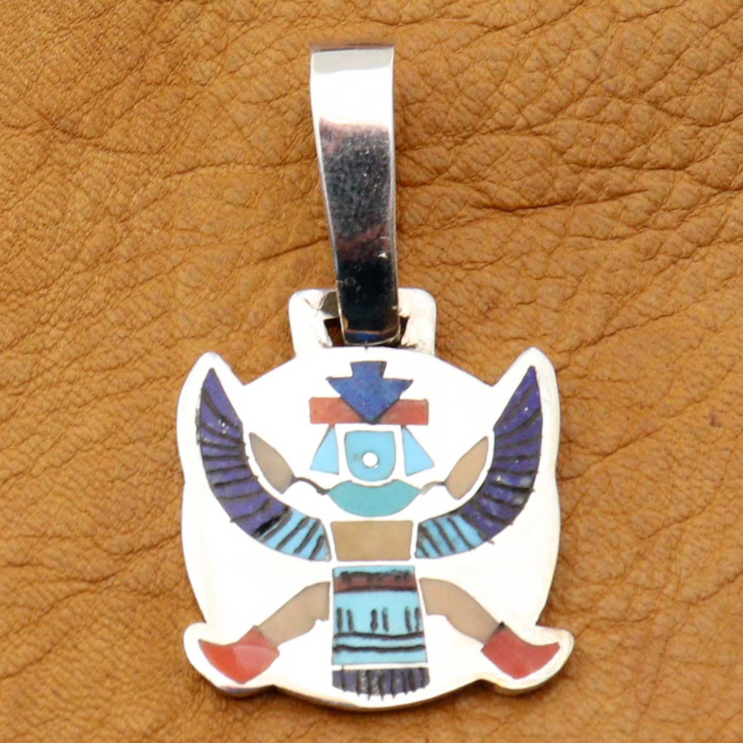 Colorful bird-shaped pendant on a brown leather background