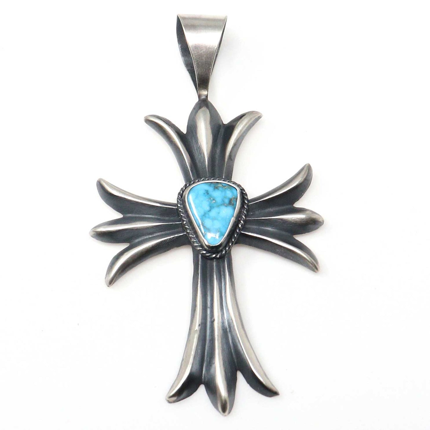Silver cross pendant with a turquoise stone on a white background